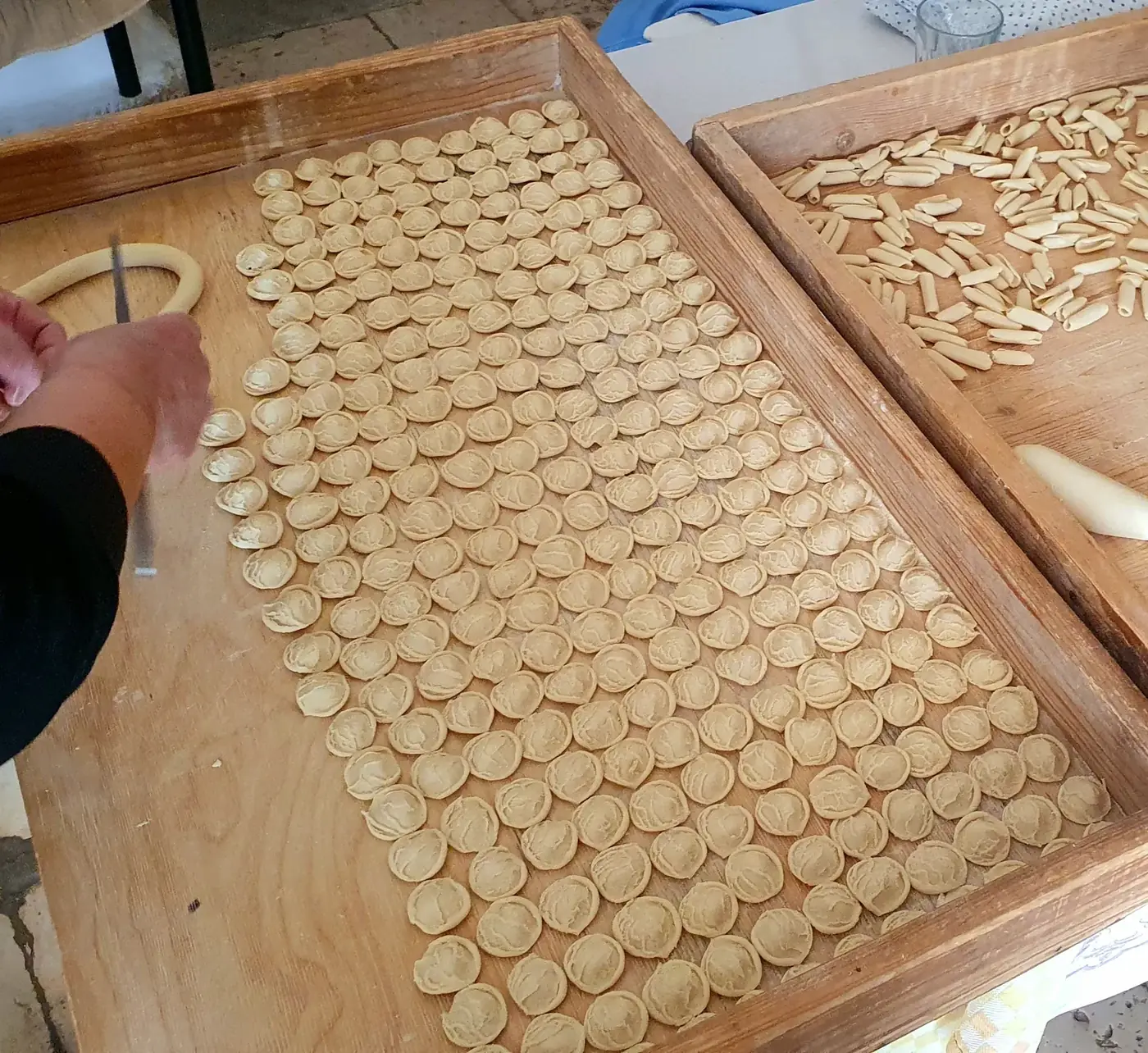 Handmade orecchiette drying on a wooden board
